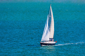 Fototapeta premium Sport sailing ship sailing through bay with calm sea and blue sky. Space to insert your text. Santander (Spain)
