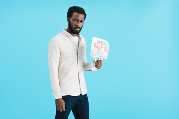 angry african american man showing newspaper with fake news isolated on blue