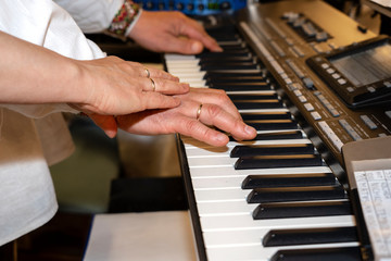 Close up of musician hands classic piano playing. Musician hands. Scene of pianist hands. Male musician playing midi keyboard synthesizer in recording studio. Pianist's hands playing the melody .