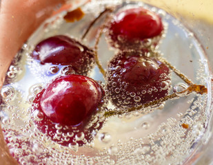 Fresh red cherry fruit in the water with bubbles splash