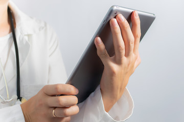 Young woman doctor with tablet computer isolated on white background close up. Health care concept.