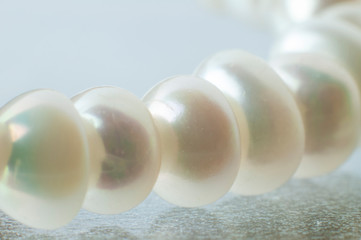 shimmering pearls lying on a glass table
