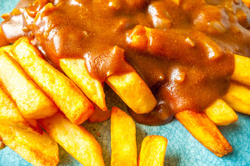 Close up of Katsu curry sauce with onions on chips / french fries - obrazy, fototapety, plakaty