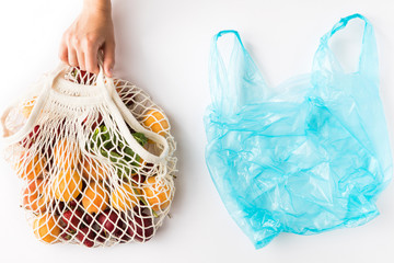 Top view of mesh shopping bag with organic eco fruits isolated on white background. Caring for the...