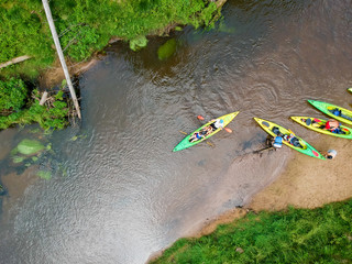 River Kayaker Aerial View. Sportsmans in Kayaks Paddling on the Scenic River Along the Shore.