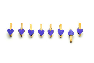Clothespins with purple hearts isolated on white background background. Festive concept in minimal style for Valentine's Day or another love event