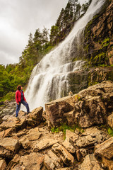 Obraz premium Tourist woman at waterfall Svandalsfossen, Norway