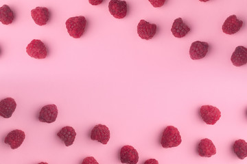ripe raspberry on a light pink background with copy space in the middle.