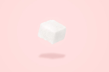 sugar cube levitating over pink background, Minimal or surrealism style. Sweet life concept.