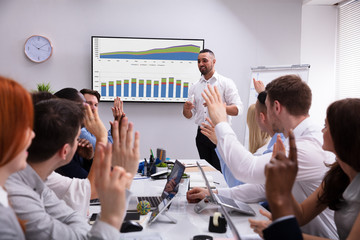 Coworkers Applauding A Colleague After Presentation