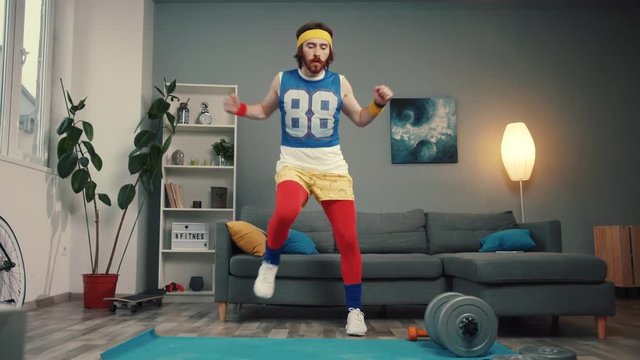 Excited joyful retro sportsman dancing into cool music warming up before hard training at home.
