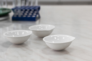 porcelain cups for evaporation of liquids standing on the table in the laboratory