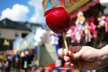 Poster sweet candy apple on county fair or festival. red candy apple covered in red caramel, at holiday vacation event or amusement park © beats_