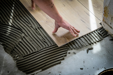 Laying tiles on the floor with a special glue.