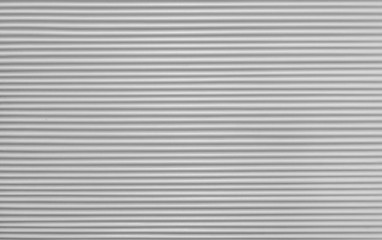 horizontal strips of cement on the wall of the building are white and gray