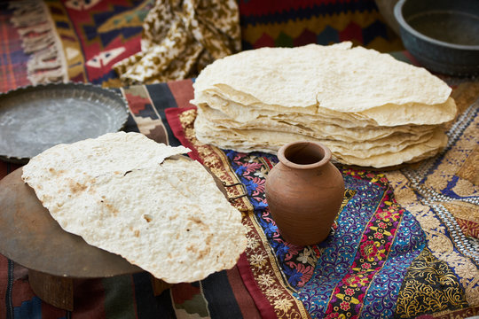 Pita bread baking on a saj or tava on fire, close-up