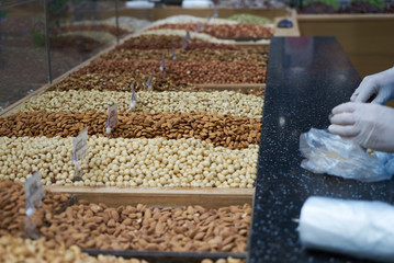 Variety of nuts on market counter, close-up. Mix of fresh nuts