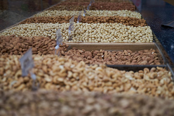 Variety of nuts on market counter, close-up. Mix of fresh nuts