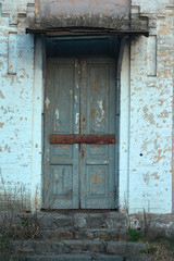 The boarded up door of the facade wall of the nineteenth century building.
