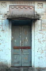 The boarded up door of the facade wall of the nineteenth century building.