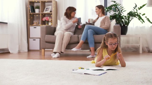 family, education and learning concept - student girl with notebook lying on floor at home and doing homework