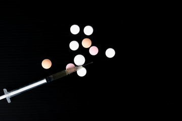 Top view different drugs - powder and pills and a syringe on a black background. Stop drug addiction. International Day against Drug abuse.  Copy space for text or advertisers.