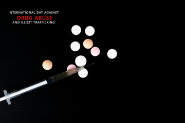 Top view different drugs - powder and pills and a syringe on a black background. Stop drug addiction. International Day against Drug abuse.  Copy space for text or advertisers.