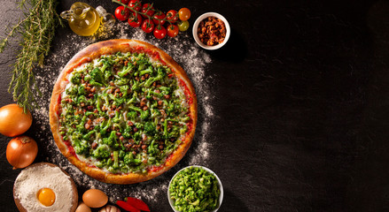 Pizza Broccoli and bacon on black concrete background. Top view, close up. Traditional Brazilian Pizza