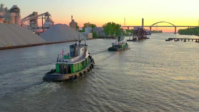 Two tugboats going to work in early morning light, sunrise, aerial drone view.