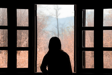 Silhouette woman looking out of window see view mountain in nature.concept thniking a freedom.