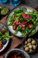 Salad with arugula, spinach, dried tomato and ham serrano paleta iberica. Low carbs keto recipe