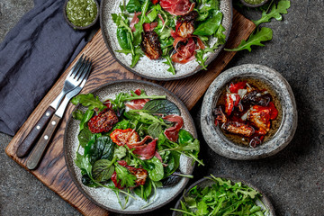 Salad with arugula, spinach, dried tomato and ham serrano paleta iberica. Low carbs keto recipe