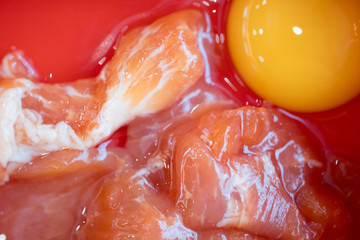 Raw pork with egg yolk on red tray