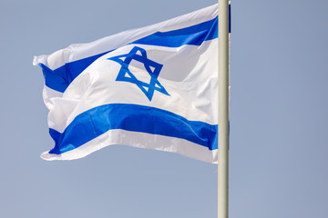 White and blue flag of Israel at morning sky