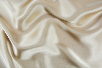 The texture of the satin fabric of beige color for the background 