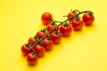 Ripe Red Cherry Tomatoes on yellow Background