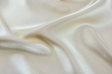 The texture of the satin fabric of beige color for the background 