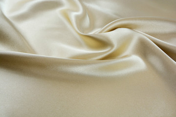 The texture of the satin fabric of beige color for the background 