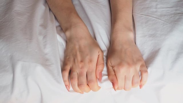 girlhands on the bed fit into the white sheet during sex