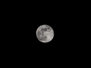 Nearly full moon against black sky
