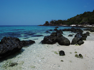 Obraz premium Ocean with rocks and foam at sand of coastline picture. Lipe Island, Thailand