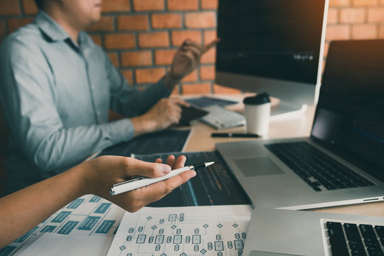 Two software developers are analyzing together about the code written into the program on the computer.