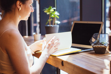 Female calligrapher dreaming in cafe. Portrait of mature business woman drinking coffee writing something in notebook. Calligraphy, lettering, graphic design handwriting, creation concept.
