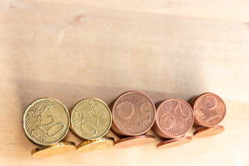 Mehrere Stapel mit EURO-Münzen zeugen von fleißigem Sparen und dem Ersparten eines Kindes