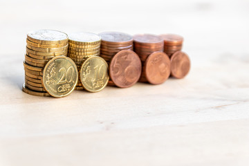 Mehrere Stapel mit EURO-Münzen zeugen von fleißigem Sparen und dem Ersparten eines Kindes