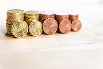 Mehrere Stapel mit EURO-Münzen zeugen von fleißigem Sparen und dem Ersparten eines Kindes