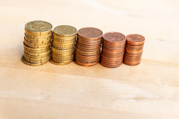 Mehrere Stapel mit EURO-Münzen zeugen von fleißigem Sparen und dem Ersparten eines Kindes