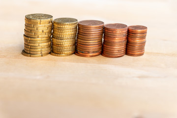 Mehrere Stapel mit EURO-Münzen zeugen von fleißigem Sparen und dem Ersparten eines Kindes