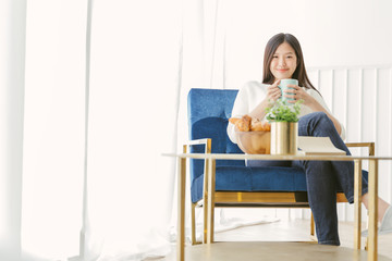 Portrait Asian woman relaxing with coffee at home