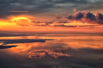 Great Salt Lake Sunset Aerial view from airplane in Wasatch Rocky Mountain Range, sweeping cloudscape and landscape during day time in Spring. In Utah, United States.